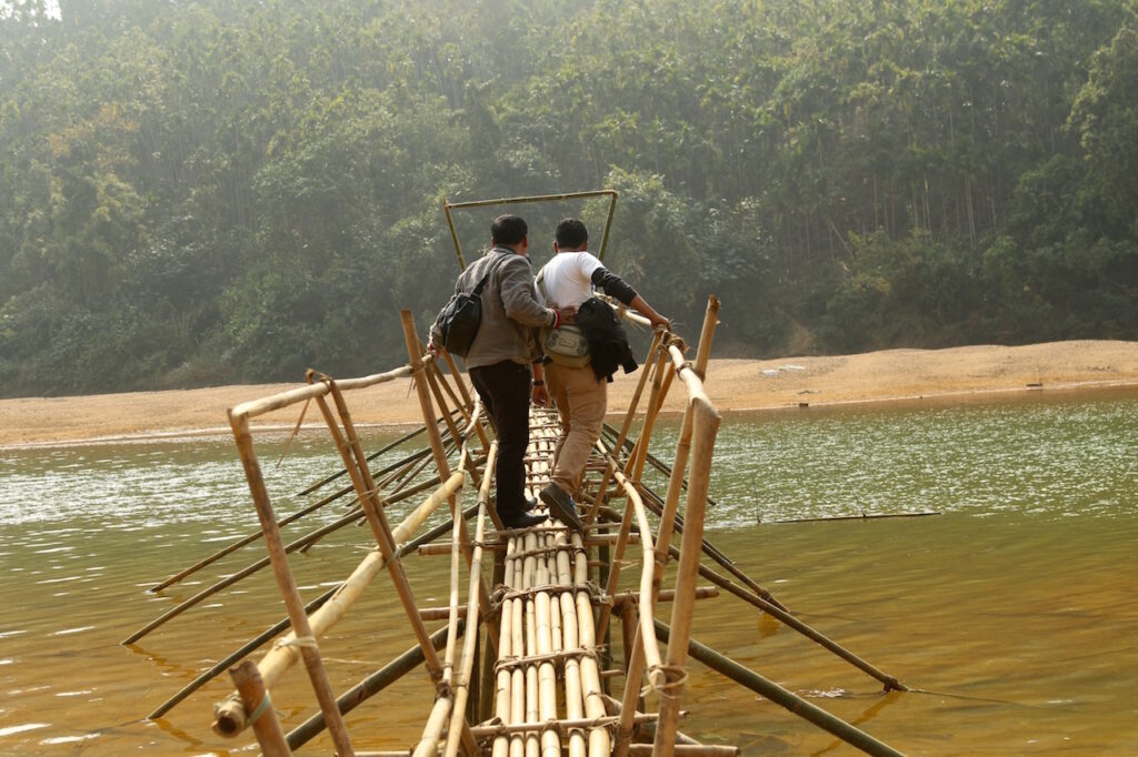 Journalists cross a bamboo bridge to interview BJALWA members and document the festival. Writers, like Mohrmen and Siangshai, have played a key role in raising public awareness on coal mining pollution and the impact on downstream livelihoods and ecology.